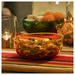 IKEA AROMATISK glass bowls styled with dried fruits, nuts and lit candle on festive striped cloth