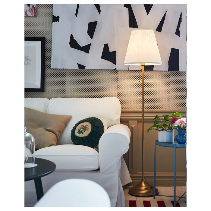 IKEA ÅRSTID brass floor lamp styled in modern living room with white sofa and colourful cushions