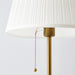  Close-up of IKEA ÅRSTID white pleated fabric shade with gold pull switch chain detail