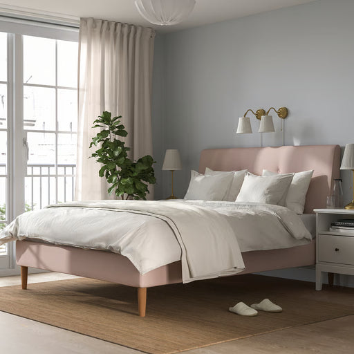 IKEA ÅRSTID brass wall lamps mounted above bed with pink pillows in styled bedroom