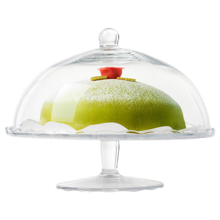 IKEA ARV BRÖLLOP serving stand with lid on a dining table, displaying a decorated cake