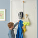 Child reaching for a helmet stored on IKEA BÄRFIS vertical door hanger