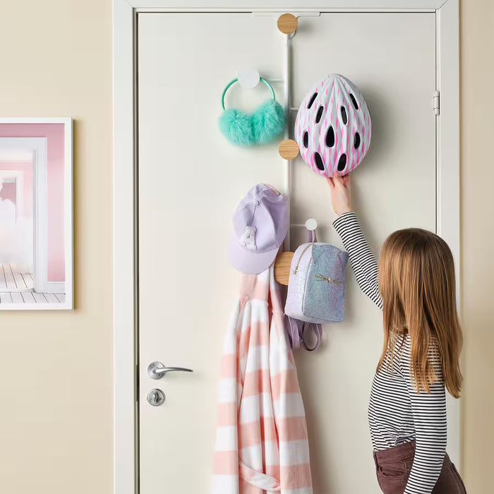 Child hanging blue clothes on IKEA BÄRFIS door hanger showing adjustable height