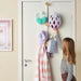 Child hanging blue clothes on IKEA BÄRFIS door hanger showing adjustable height