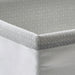 Close-up of IKEA BAXNA grey fabric organiser corner showing textured recycled polyester weave