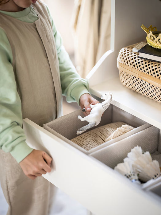  Person opening IKEA BAXNA organiser storing white linens next to a bright window