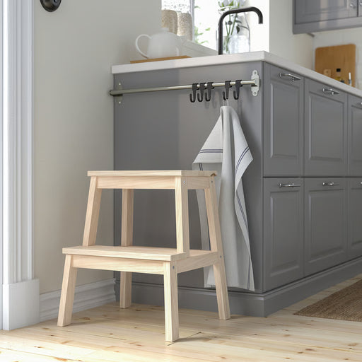 IKEA BEKVÄM aspen step stool placed beside grey kitchen cabinets in modern kitchen