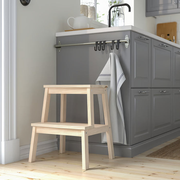 IKEA BEKVÄM aspen step stool placed beside grey kitchen cabinets in modern kitchen