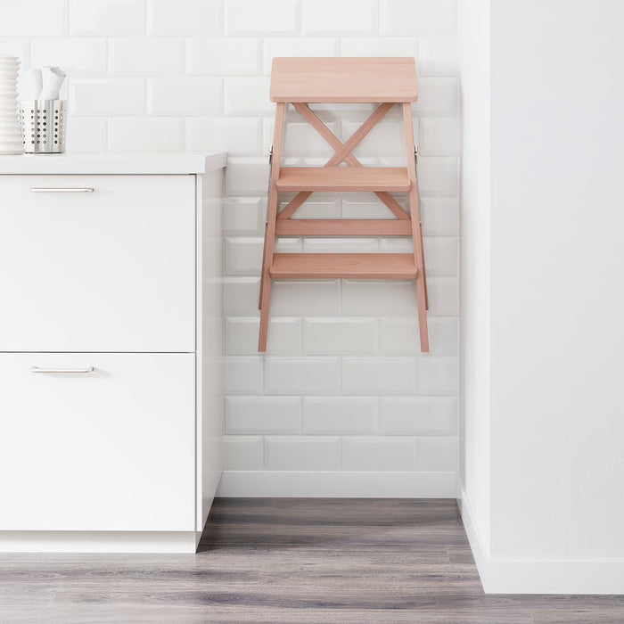  IKEA BEKVÄM beech step stool folded leaning against white tiled kitchen wall