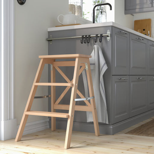  IKEA BEKVÄM beech step stool folded next to kitchen cabinets showing slim profile