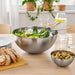 IKEA BLANDA BLANK stainless steel serving bowl filled with fresh green salad on a dining table