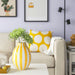 IKEA BLODBJÖRK yellow striped vase with green succulents on table beside sofa and polka dot pillow