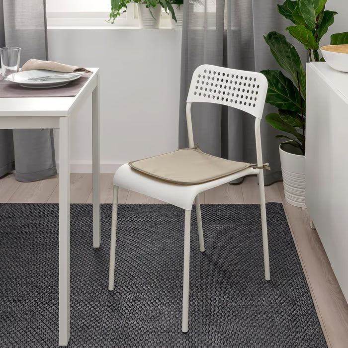 IKEA BRÄMÖN grey-beige chair pad on a wooden dining chair in a kitchen setting