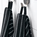 Two IKEA BROKGINST black towels hanging on hooks showing textured and soft sides