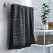 IKEA BROKGINST black towel hanging in modern tiled bathroom near window
