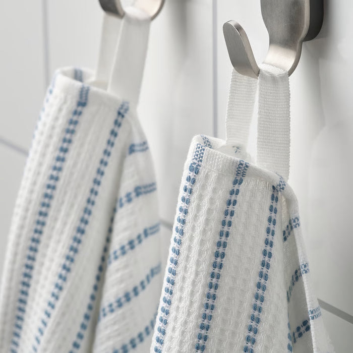 Close-up of folded IKEA BROKGINST white bath towels showing waffle side and terry side detail