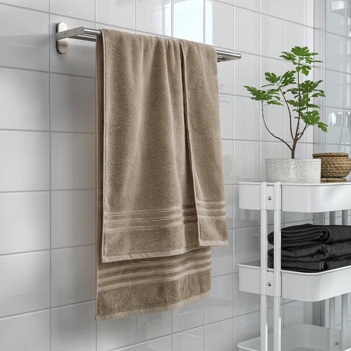 Three IKEA BROKGLIM beige towels hanging on bathroom hooks neatly organised
