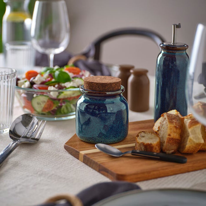 Close-up of IKEA's airtight BRUGDHAJ jar showing blue tinted glass and secure plastic lid sealing"