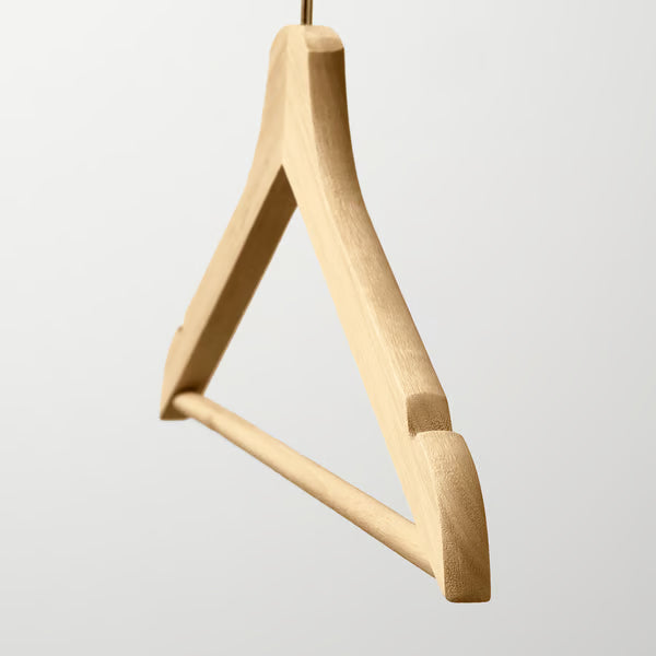 Close-up of IKEA BUMERANG wooden hanger showing grooves and chrome-plated steel hook