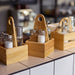 Three IKEA CHOKLADHAJ wooden spice organisers arranged on white counter holding jars and bottles