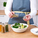 Person sprinkling spices from IKEA CITRONHAJ jar over a fresh salad