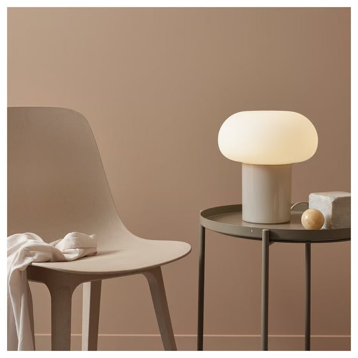 IKEA DEJSA lamp on bedside table in cosy bedroom with grey and pink pillows
