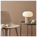 IKEA DEJSA lamp on bedside table in cosy bedroom with grey and pink pillows