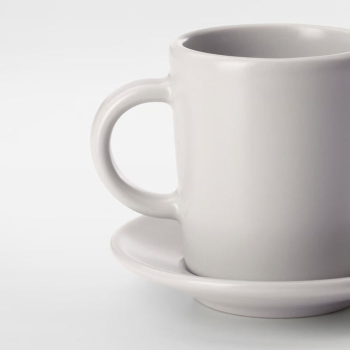  IKEA DINERA beige stoneware espresso cup and saucer on rustic table setting side angle