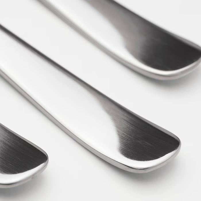Three IKEA DRAGON polished stainless steel spoons close-up showing sleek timeless design