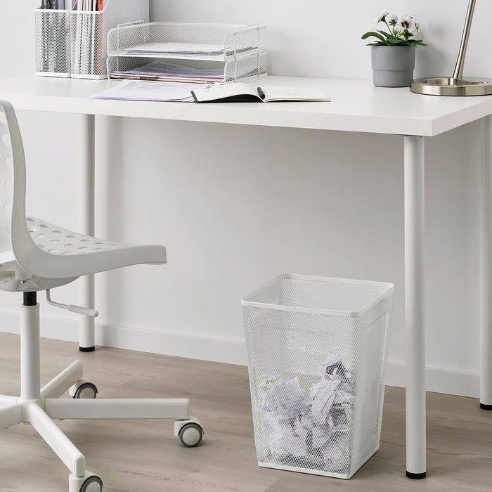  White IKEA DRÖNJÖNS wastebasket placed beside a desk showing size in a home office