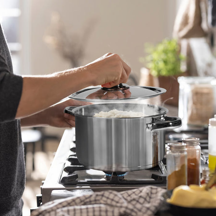 Person placing lid on IKEA DVÄRGKRÄFTA stainless steel saucepan on stove