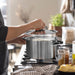 Person placing lid on IKEA DVÄRGKRÄFTA stainless steel saucepan on stove