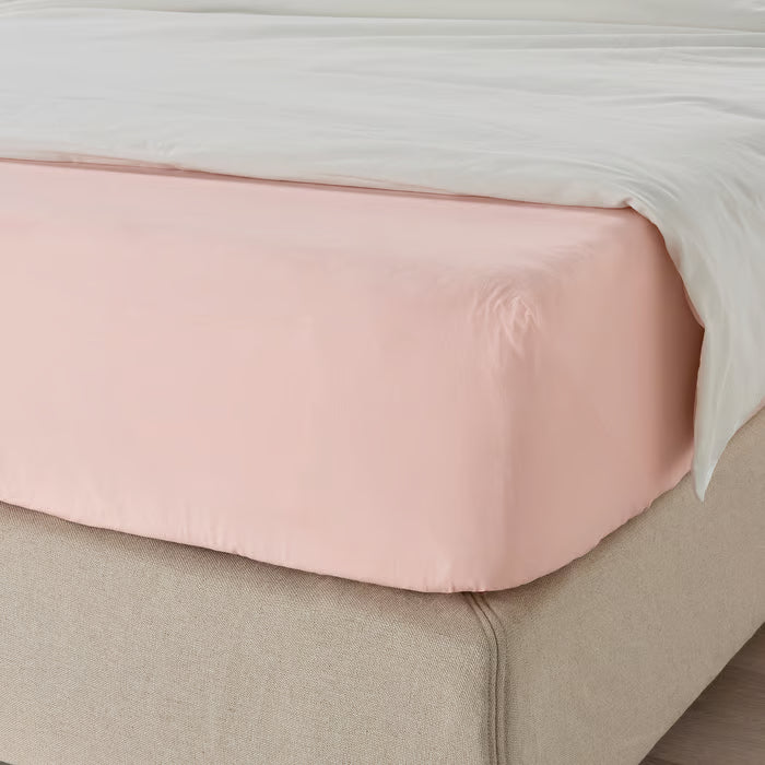 IKEA DVALA light pink fitted sheet on a neatly made bed with elastic edges securing the mattress
