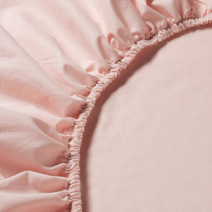 Close-up of IKEA DVALA light pink fitted sheet fabric showing smooth soft cotton texture and elastic edge