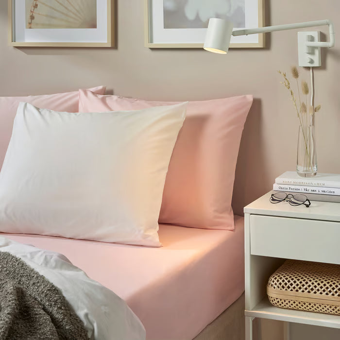 Bedroom styled with IKEA DVALA light pink cotton sheet pillows and blanket with white side table
