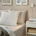  IKEA DVALA beige flat sheet styled on a made bed with light pillows and bedside table neutral bedroom