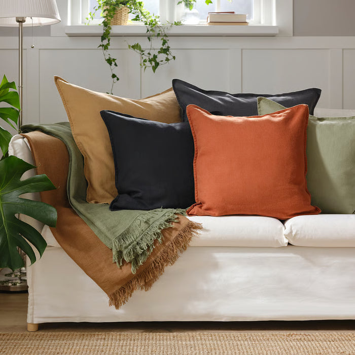IKEA DYTÅG dark beige cushion cover with colourful mustard and blue cushions on white sofa