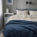 IKEA DYTÅG soft dark blue linen-cotton blend throw blanket draped on a bed