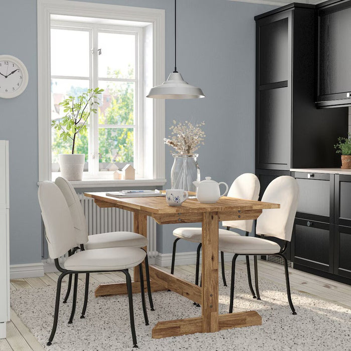 Idekulla beige EBBALYCKE chair placed in a cozy dining area, showcasing its versatile Scandinavian style for apartments and cafes.