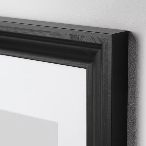 Close-up of IKEA EDSBRUK black stained frame showing fibreboard construction and plastic front protection