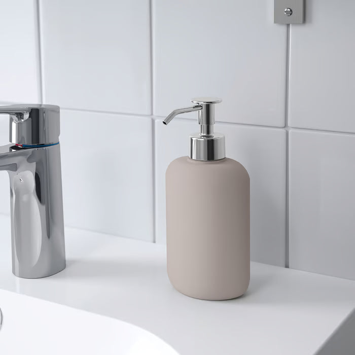 KEA EKOLN beige soap dispenser placed beside bathroom sink, styled with coordinating EKOLN accessories