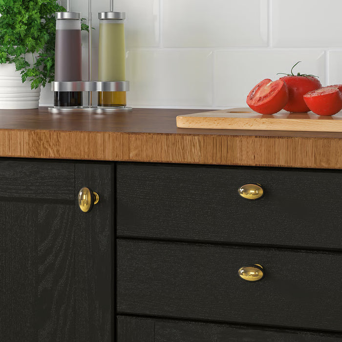 IKEA ENERYDA brass knobs on black kitchen cabinet with wooden countertop, tomatoes and herbs