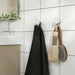 IKEA ENUDDEN white hook mounted on bathroom wall with towel hung in use context