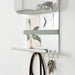 Wall-mounted organizer with hooks and a basket on a white wall.