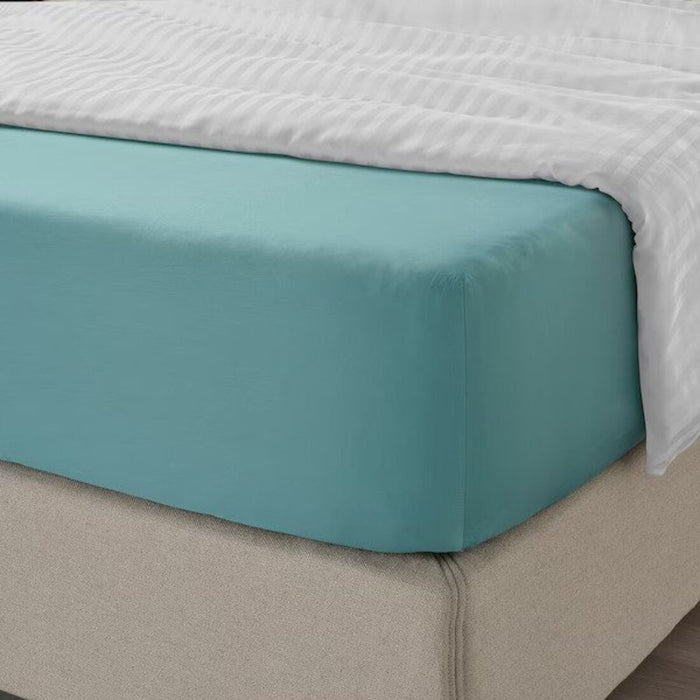 A closeup image of IKEA fitted sheet on a bed with neatly tucked corners and a smooth surface 10486572