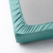 A close-up photo of an IKEA fitted sheet in Grey-Turquoise with elastic edges to fit snugly over a mattress 10486572