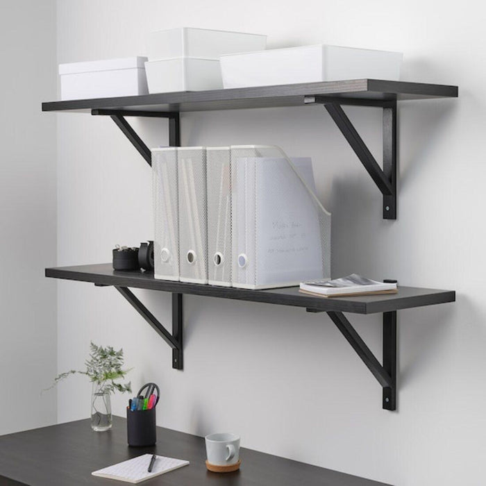 Wall-mounted black metal shelves with office supplies on a white wall.