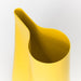 A close up image of dual-purpose vase and watering can in a cheerful yellow color