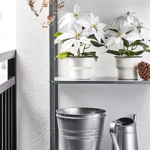 Indoor setting featuring the IKEA VINTERFINT Poinsettia Artificial Plant as a festive centerpiece.