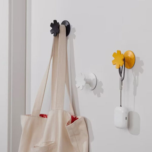The JORDBORR Hook adding a decorative touch to a bedroom wall, with a bag hanging from it